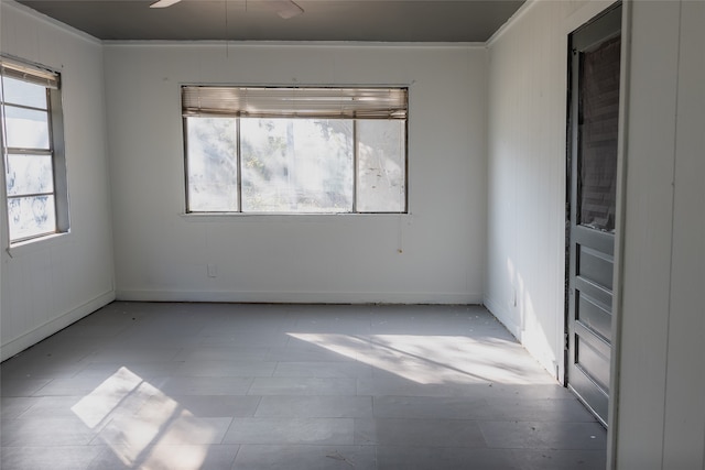 empty room featuring ceiling fan and ornamental molding