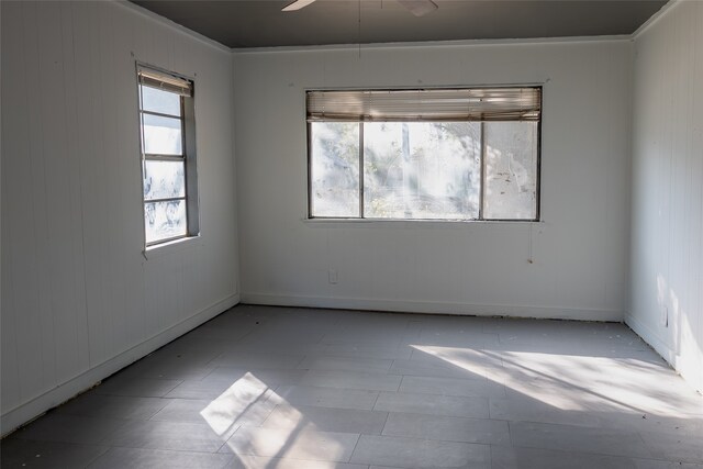 unfurnished room featuring wooden walls and ceiling fan