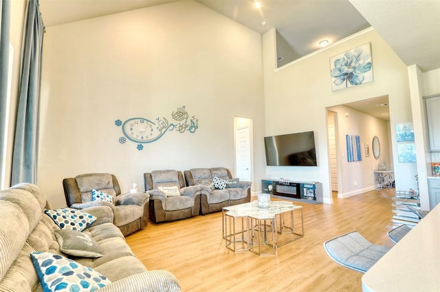 living room with high vaulted ceiling and light hardwood / wood-style flooring