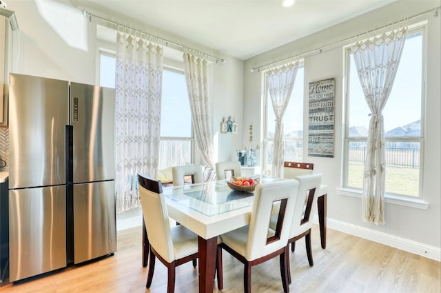 dining space featuring plenty of natural light and light hardwood / wood-style flooring