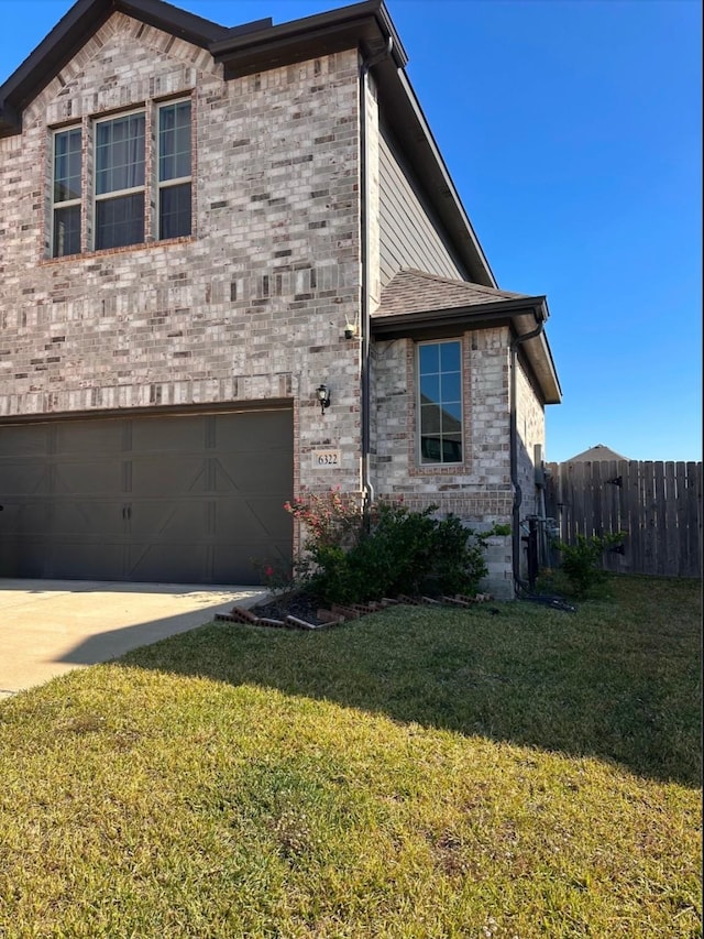 view of side of property featuring a yard and a garage