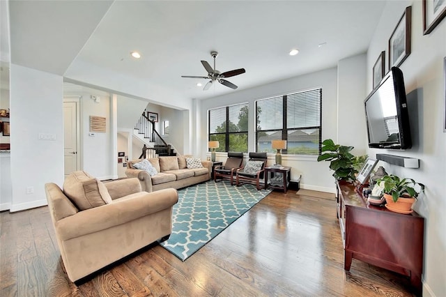 living room featuring dark wood-type flooring and ceiling fan