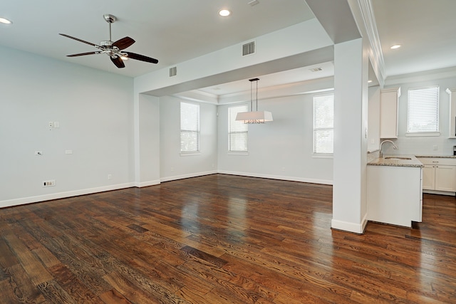 unfurnished living room with ornamental molding, sink, ceiling fan, and dark hardwood / wood-style flooring