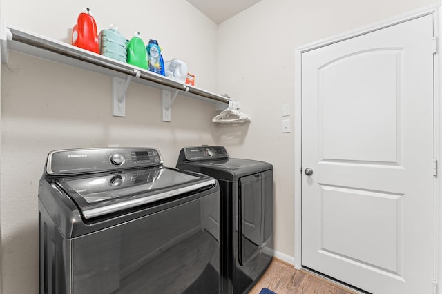 laundry room featuring separate washer and dryer and hardwood / wood-style floors