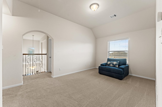 unfurnished room with a notable chandelier, vaulted ceiling, and carpet floors