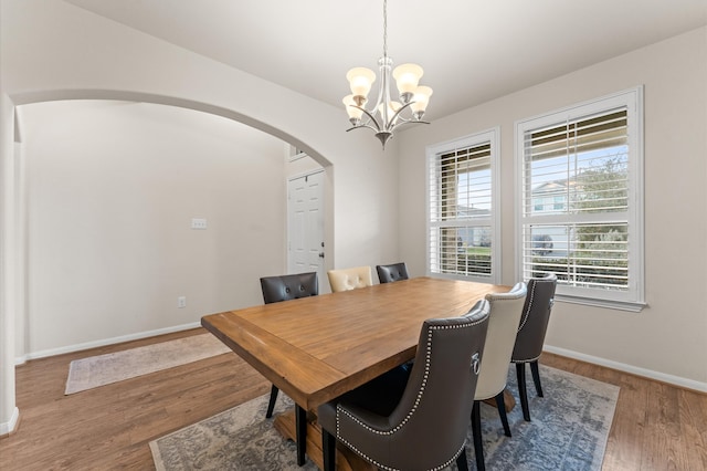 dining room with dark wood-type flooring and a notable chandelier