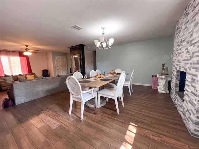 dining area with hardwood / wood-style floors, a fireplace, and ceiling fan with notable chandelier