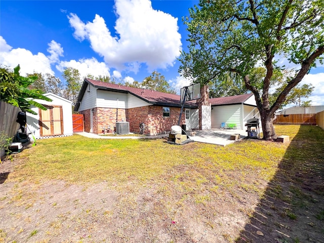 rear view of property featuring a yard, a patio area, and central AC unit