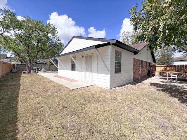 back of house with a yard and a patio