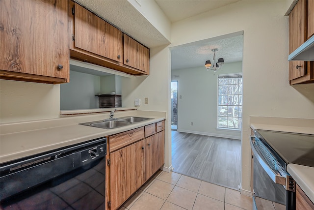 kitchen with black dishwasher, sink, light wood-type flooring, electric stove, and a textured ceiling