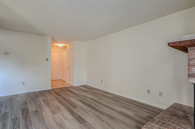 empty room featuring light hardwood / wood-style floors and a textured ceiling