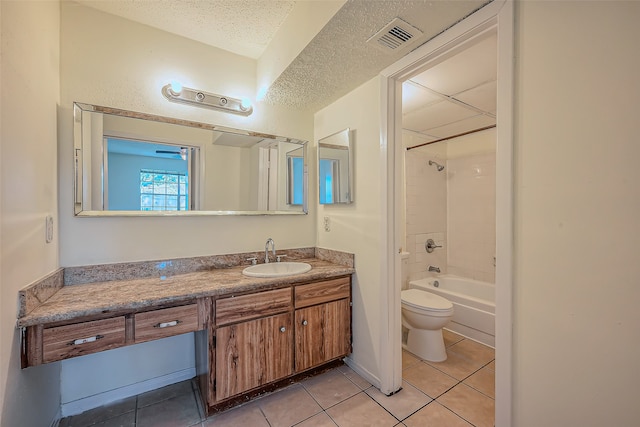 full bathroom with toilet, tile patterned flooring, tiled shower / bath, vanity, and a textured ceiling