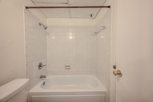 bathroom with toilet and tiled shower / bath