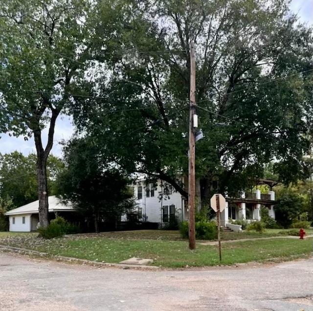 view of property hidden behind natural elements featuring a front yard