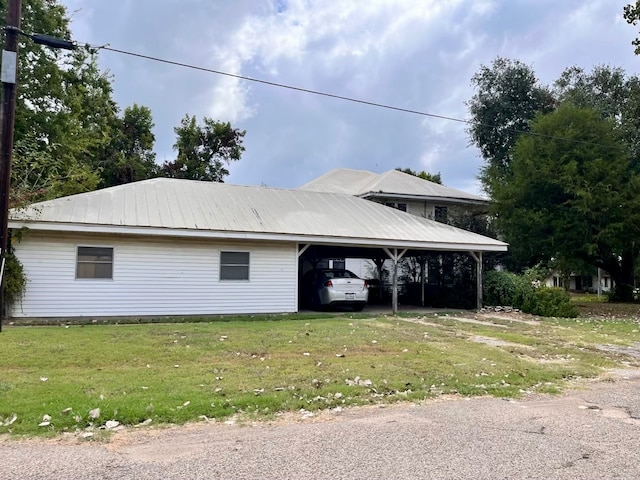 view of home's exterior featuring a carport and a lawn