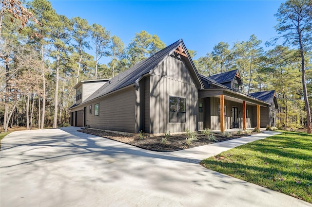 view of property exterior featuring a garage, covered porch, and a yard