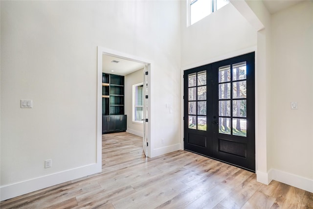 entrance foyer with french doors and light hardwood / wood-style floors