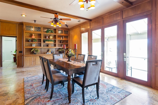 dining room featuring wood walls, french doors, beamed ceiling, built in shelves, and ceiling fan