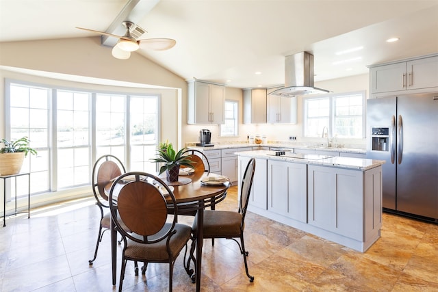 kitchen featuring island range hood, stainless steel refrigerator with ice dispenser, a center island, vaulted ceiling, and gray cabinets