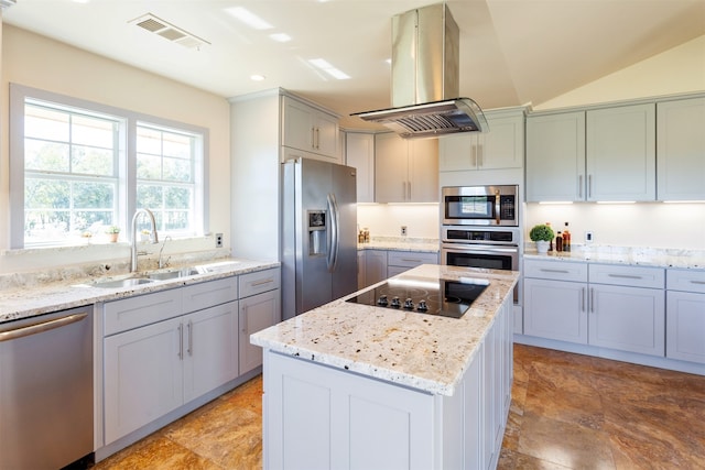 kitchen with island range hood, lofted ceiling, stainless steel appliances, a center island, and light stone countertops