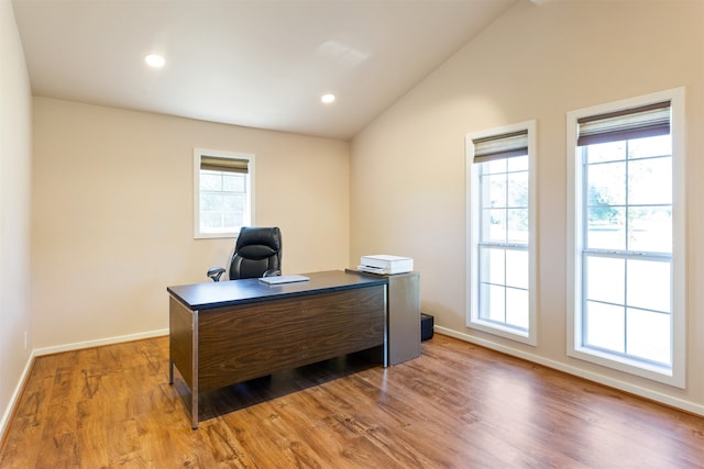 office area with lofted ceiling, light hardwood / wood-style flooring, and a healthy amount of sunlight