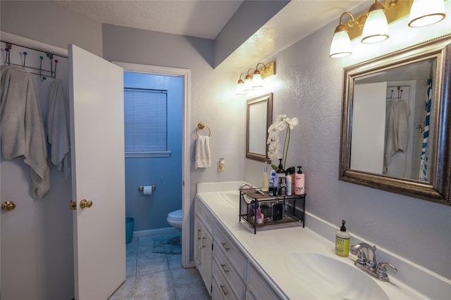 bathroom with a textured ceiling, vanity, and toilet