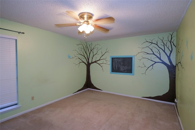 spare room featuring ceiling fan, light colored carpet, and a textured ceiling