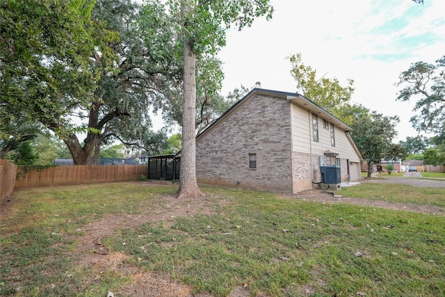 view of yard with central AC unit and a garage