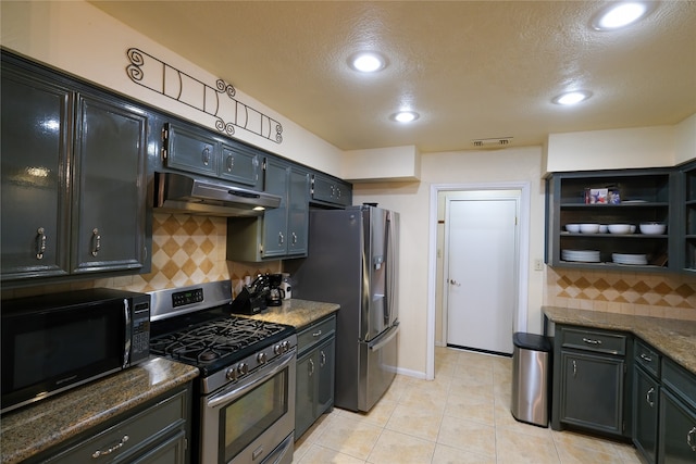 kitchen with backsplash, dark stone countertops, light tile patterned floors, and stainless steel appliances