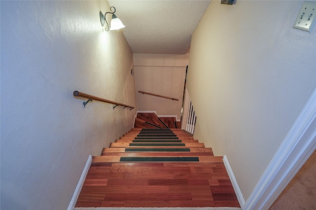 stairway with a textured ceiling