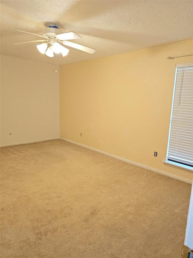 carpeted spare room featuring ceiling fan and a textured ceiling