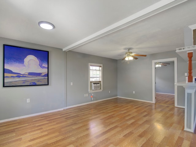 spare room with ceiling fan, cooling unit, light hardwood / wood-style flooring, and beam ceiling