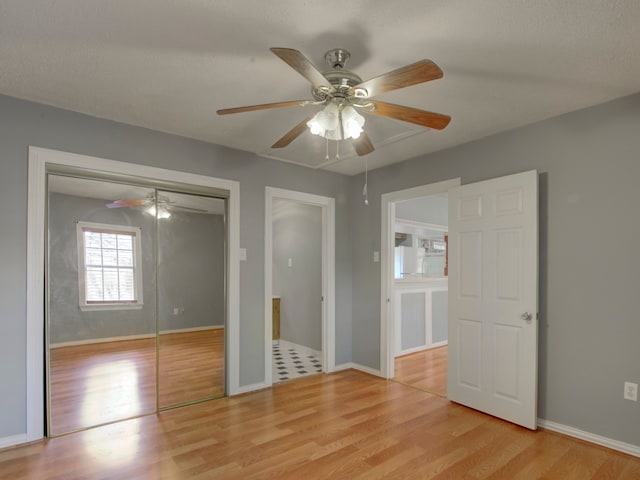 unfurnished bedroom featuring ceiling fan, a textured ceiling, and light wood-type flooring