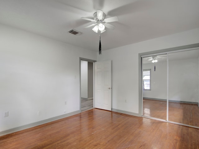 unfurnished bedroom featuring a closet, ceiling fan, and wood-type flooring