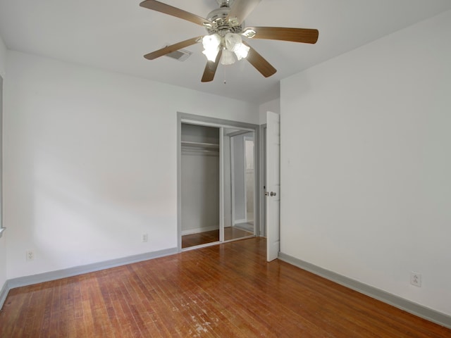 unfurnished bedroom featuring a closet, hardwood / wood-style floors, and ceiling fan