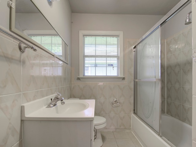 full bathroom featuring enclosed tub / shower combo, tile walls, toilet, vanity, and tile patterned floors