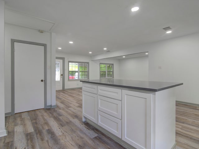 kitchen featuring white cabinetry, a center island, and light wood-type flooring