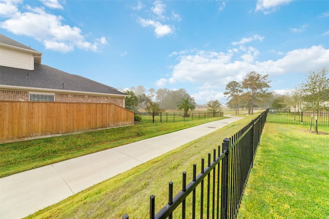 view of community with a lawn and a rural view