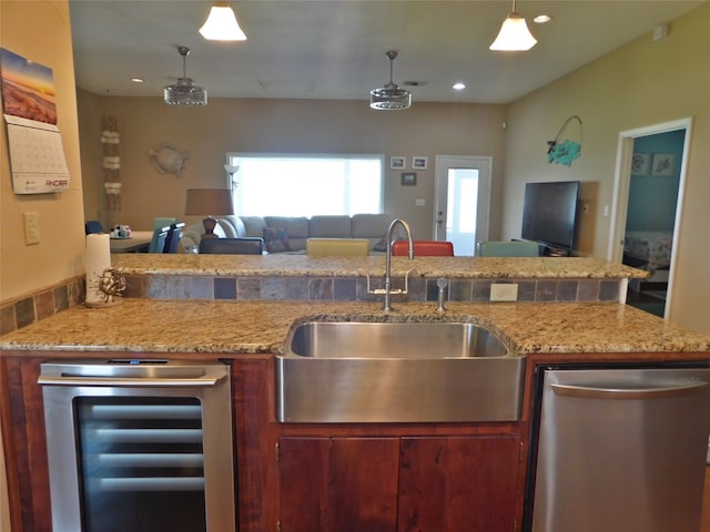 kitchen featuring dishwasher, hanging light fixtures, sink, light stone countertops, and beverage cooler