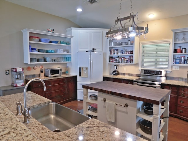 kitchen featuring white fridge with ice dispenser, sink, wooden counters, vaulted ceiling, and stainless steel stove