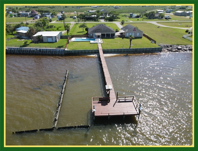 view of dock with a yard and a water view