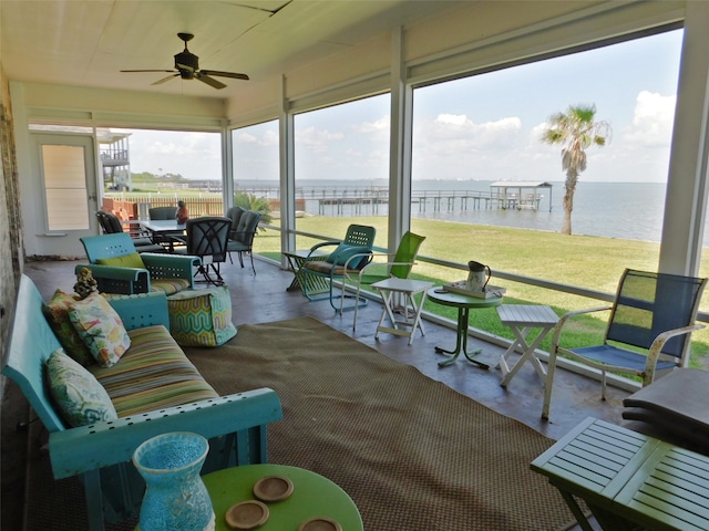 sunroom / solarium featuring a water view and ceiling fan