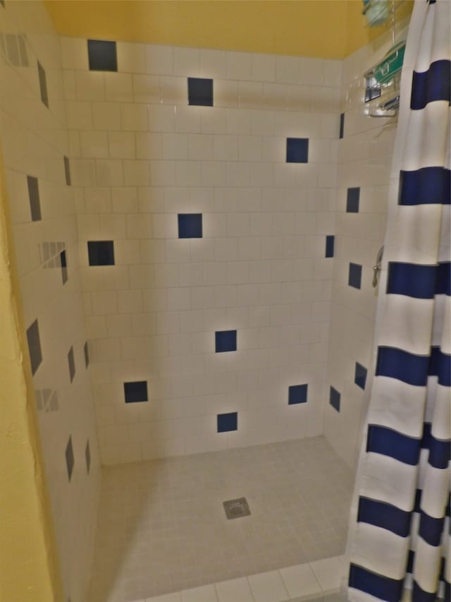 bathroom with a shower with curtain and tile patterned floors