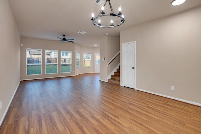 unfurnished living room with hardwood / wood-style floors and ceiling fan with notable chandelier