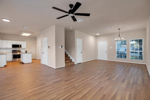 unfurnished living room with light hardwood / wood-style floors and ceiling fan with notable chandelier