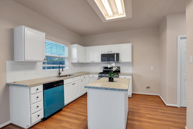 kitchen with white cabinetry, sink, stainless steel appliances, light stone counters, and a kitchen island