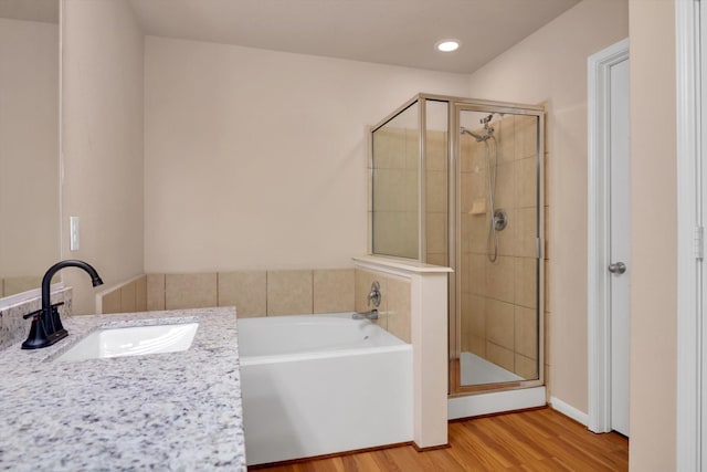 bathroom with separate shower and tub, sink, and wood-type flooring