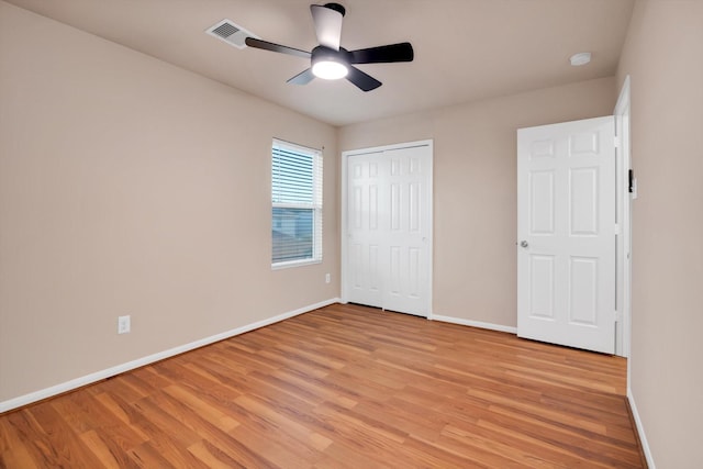 unfurnished bedroom featuring a closet, light hardwood / wood-style flooring, and ceiling fan