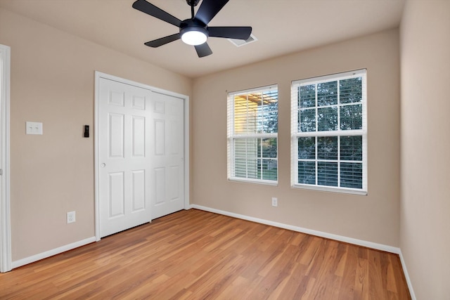 unfurnished bedroom with ceiling fan, a closet, and light hardwood / wood-style floors