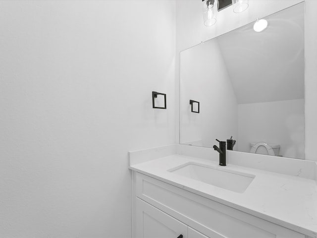 bathroom featuring vanity and lofted ceiling